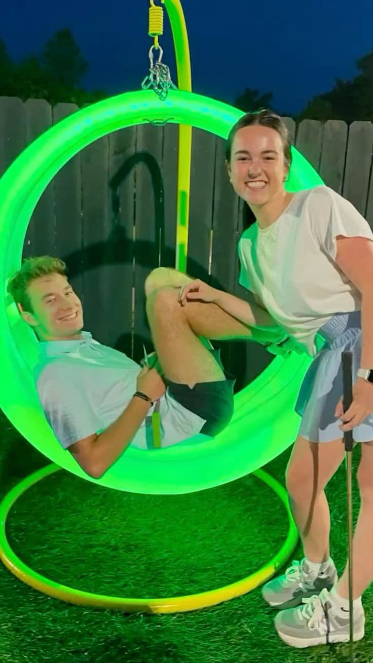 Couple at the green glow swing chair after sunset