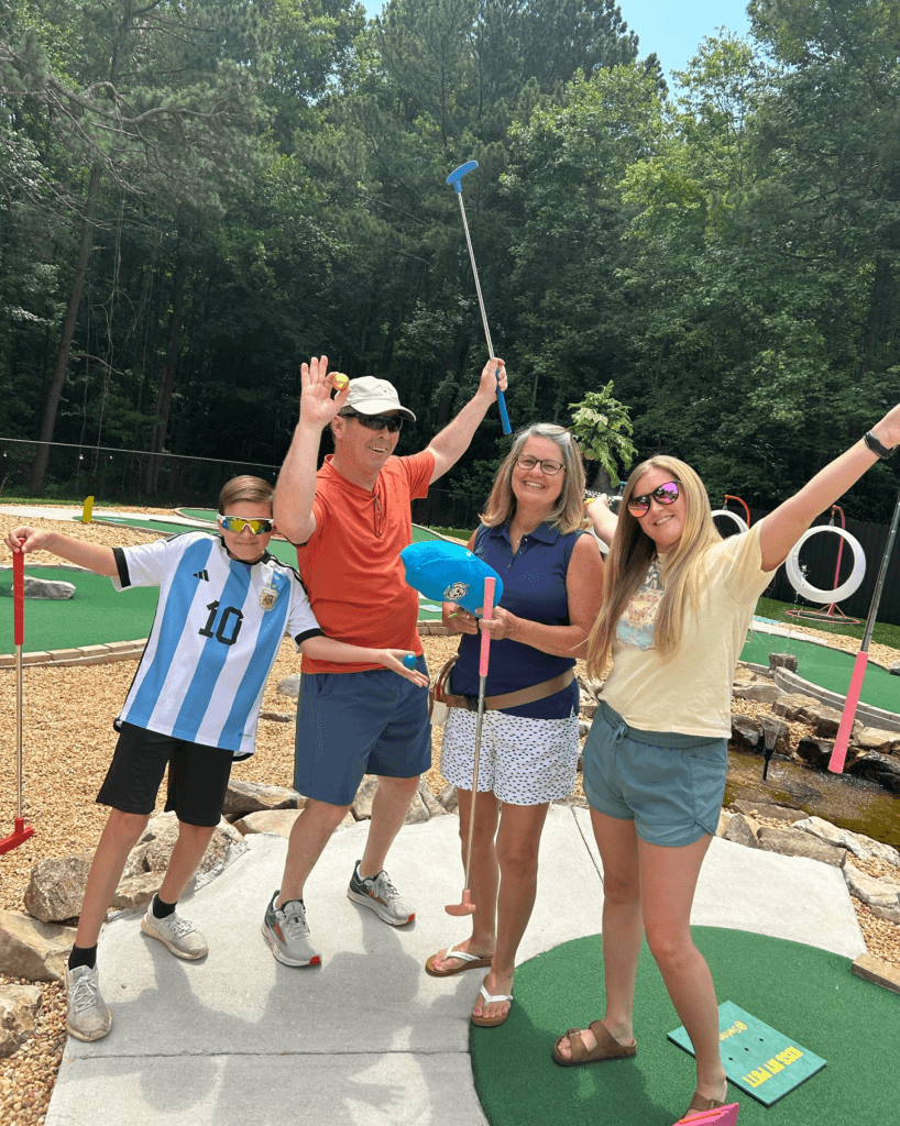 Friends celebrating at Swing ATL mini golf course